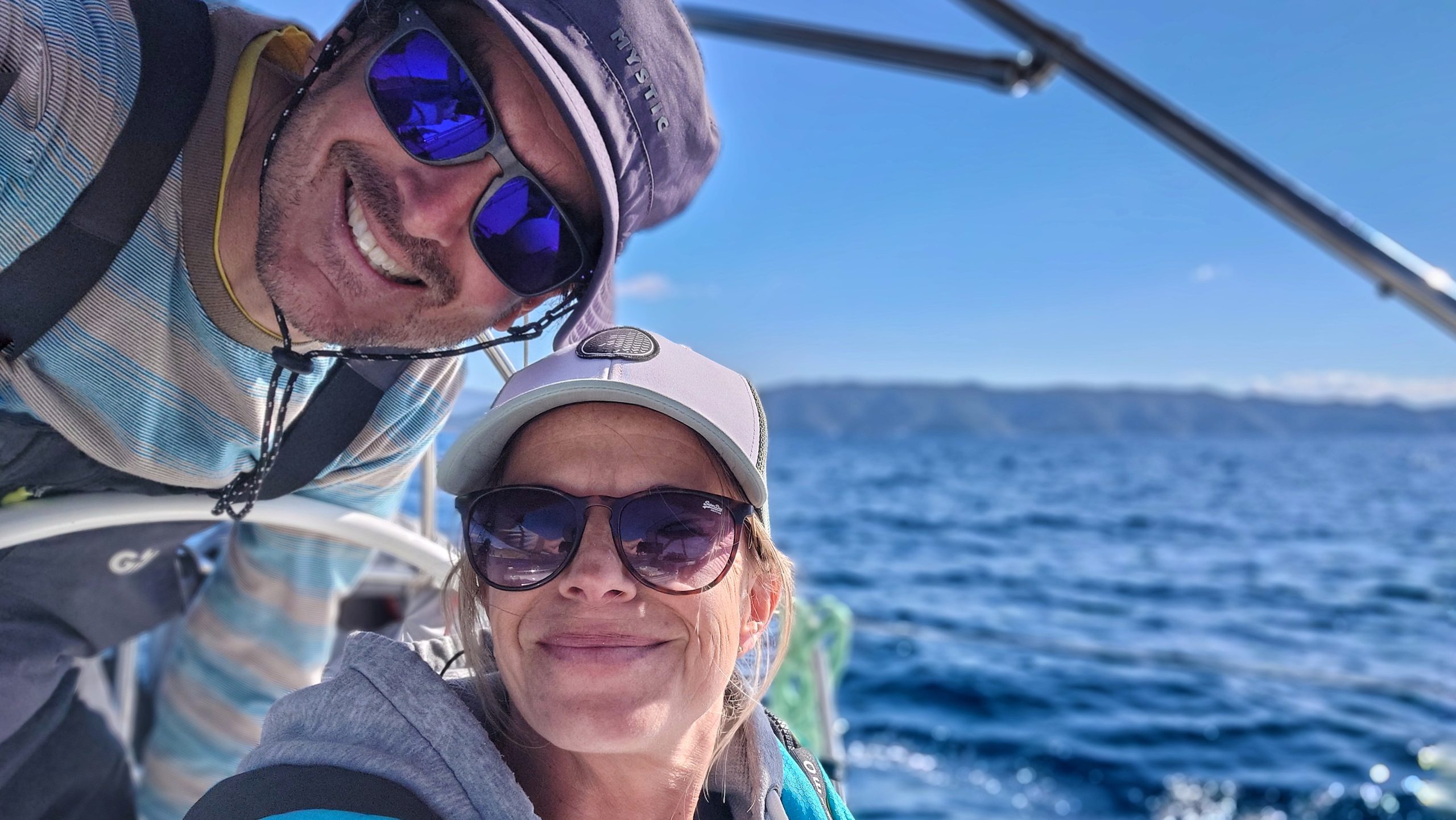 Dave and Karin at the wheel in the cockpit of their sailing yacht.